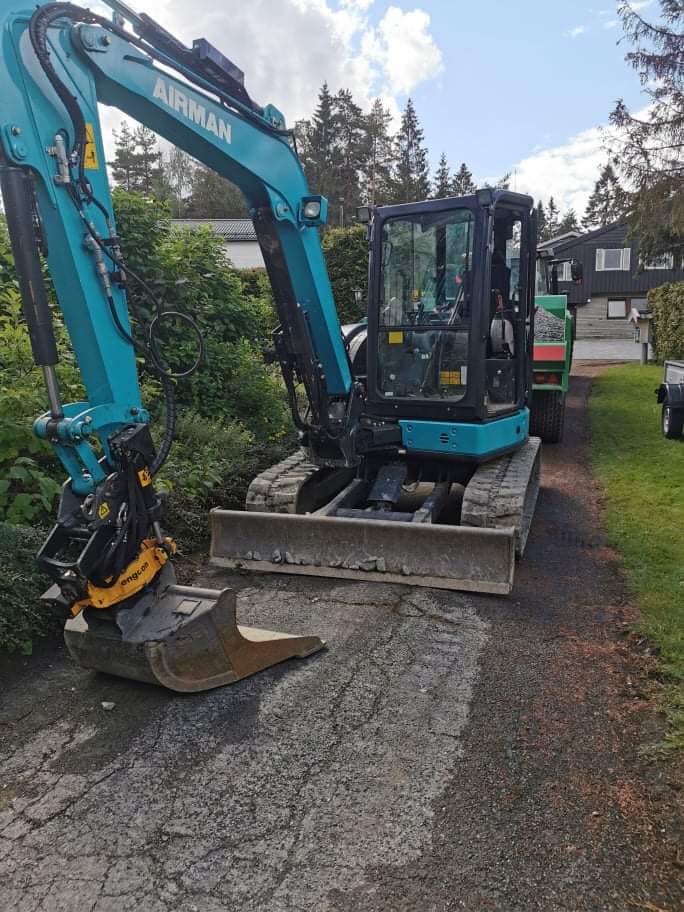 Gravemaskin står i en oppkjørsel