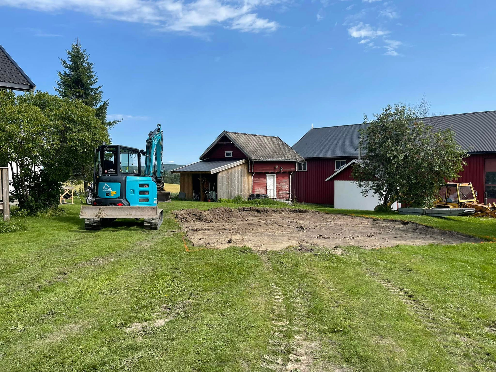 Gravemaskin utfører tomtegraving